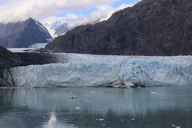 A massive blue glacier calving into the ocean in the Alaskan wilderness